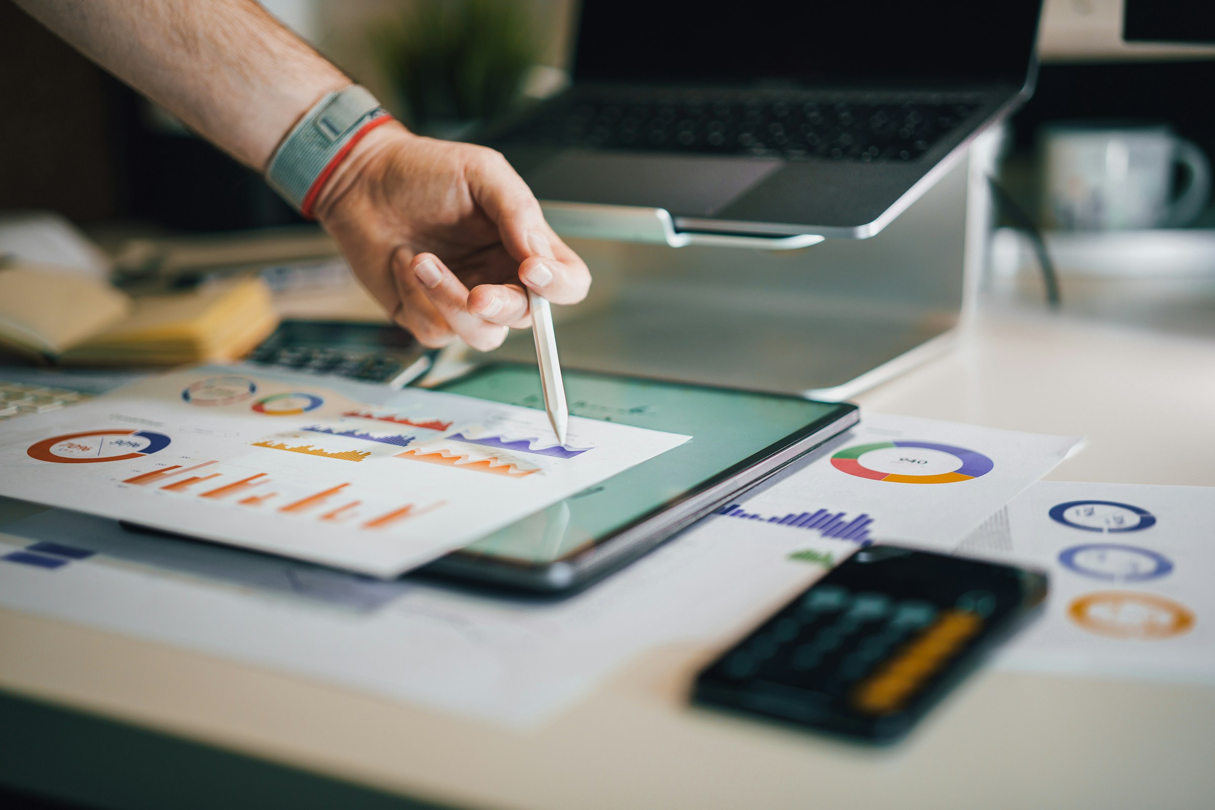 Hand pointing at graphs to explain a debt consolidation strategy.