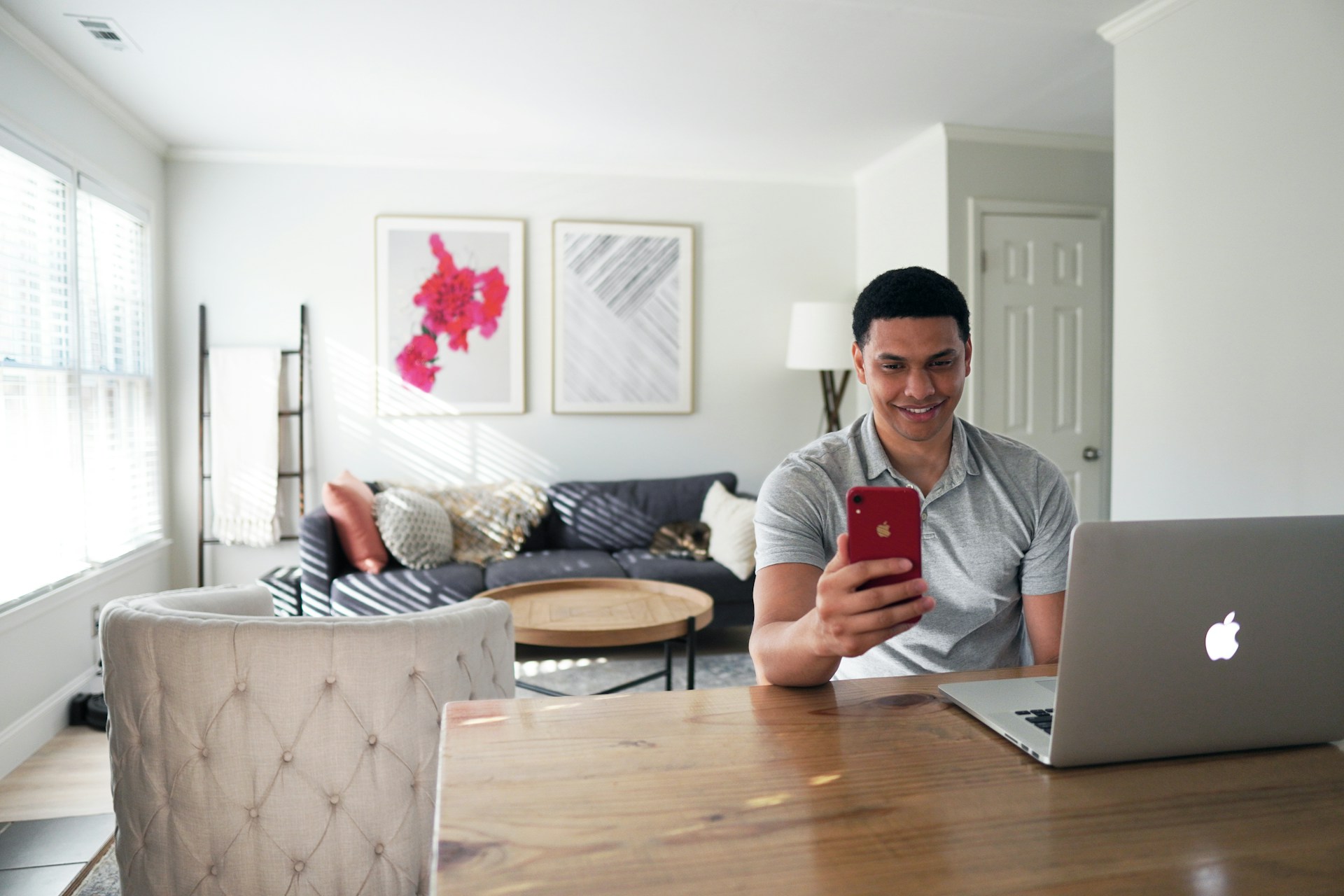 Man in beautiful home using his phone and laptop